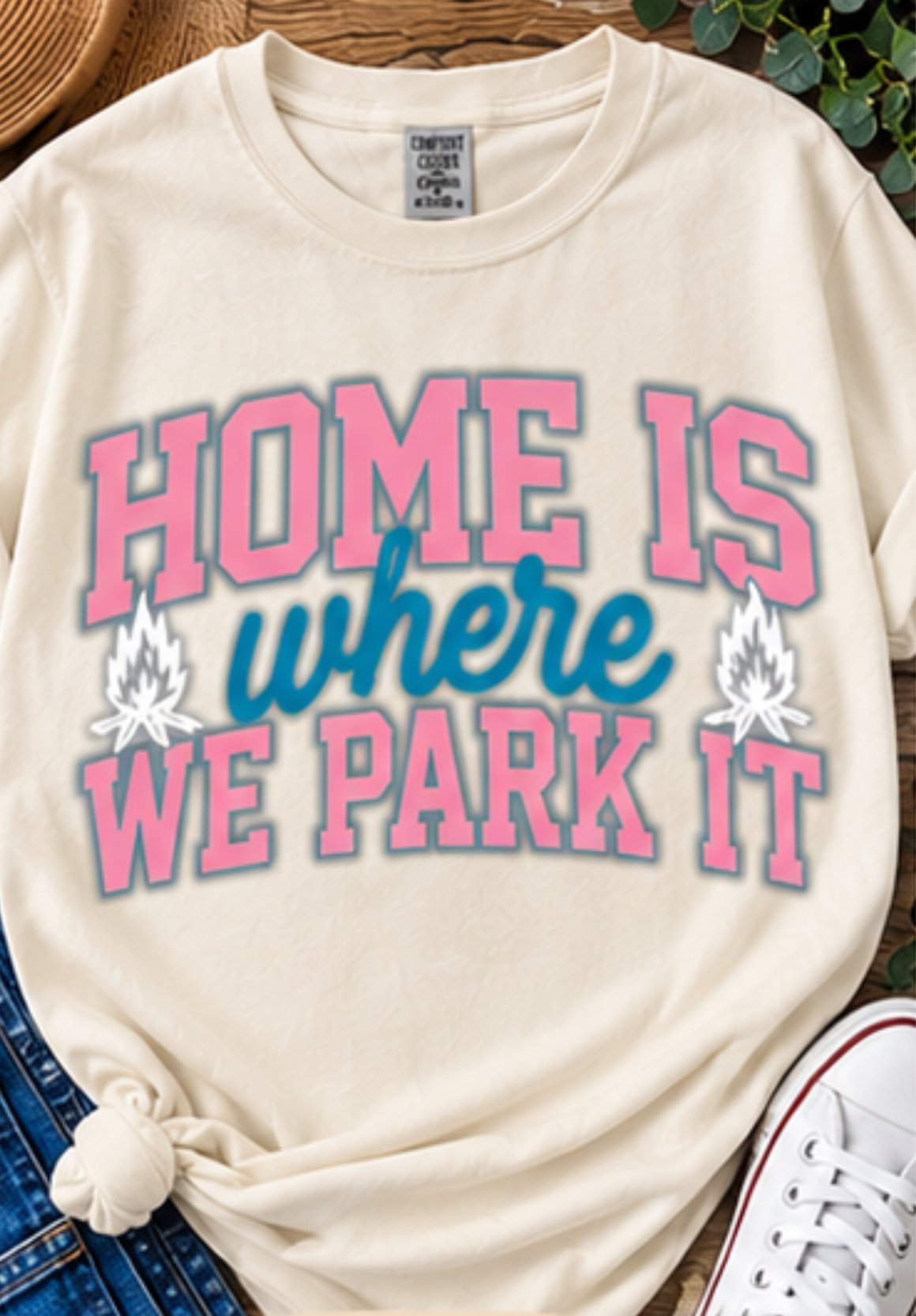 Cream sweatshirt with pink and blue text reading Home is where we park it with camping details